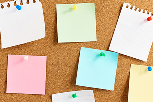 Colorful blank sticky notes on cork board